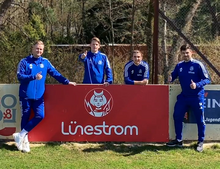 Vier Spieler der SV Eintracht, die in ihrer Mitte eine Lünestrom-Bande präsentieren.