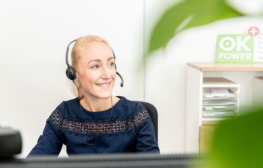 Eine Lünestrom-Mitarbeiterin telefoniert lächelnd über ein Headset.