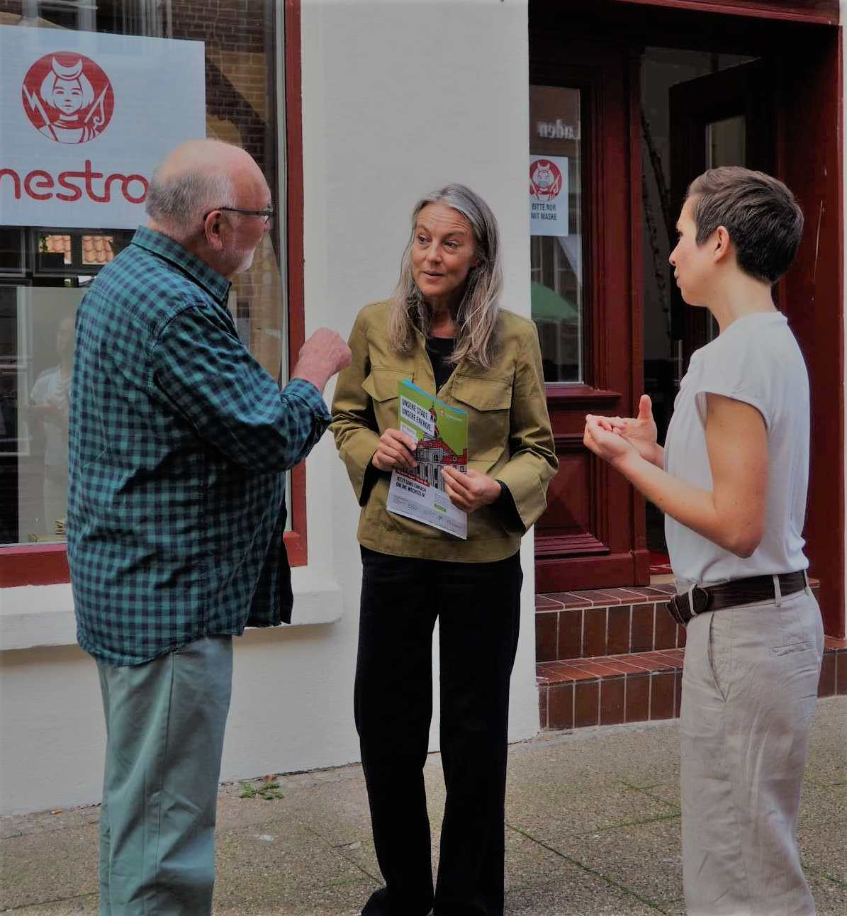 Winfried Harendza, Christiane Finner (Geschäftsführerin der VHS Region Lüneburg) und Jowana Lohmöller (Lünestrom) unterhalten sich vor dem Lünestrom ServiceCenter.