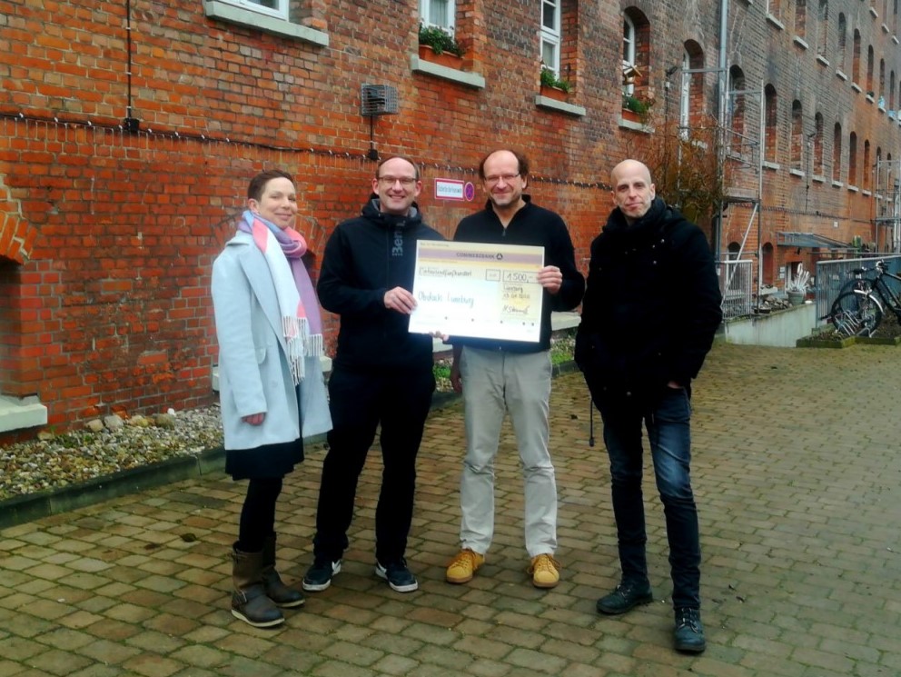 Jowana Lohmöller und Malte Steinmetz (Lünestrom) übergeben eine Spende an Dieter Koschel (Leiter der HERBERGEplus) und André Pluskwa.